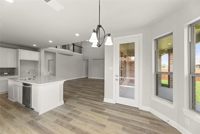 4100 Pond Cypress St, Aubrey, TX 76227 - kitchen featuring stainless steel dishwasher, a sink, light countertops, white cabinets, and light wood-style floors