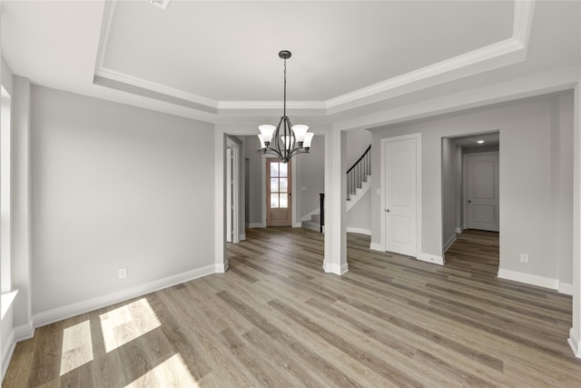 4100 Pond Cypress St, Aubrey, TX 76227 - unfurnished dining area with stairs, a tray ceiling, an inviting chandelier, and light wood-type flooring