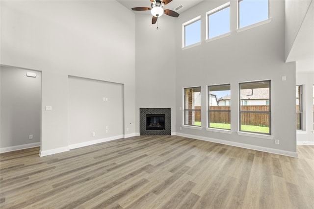 4100 Pond Cypress St, Aubrey, TX 76227 - unfurnished living room with visible vents, a towering ceiling, baseboards, ceiling fan, and light wood-type flooring