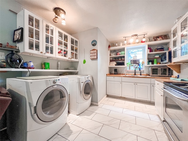 laundry room with washing machine and dryer, sink, and a textured ceiling