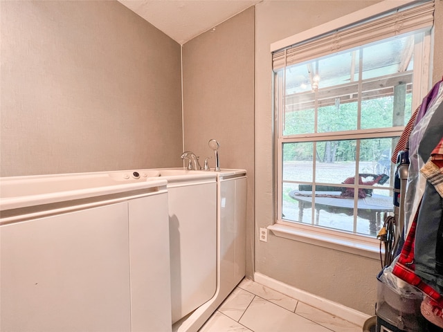 washroom featuring laundry area, washing machine and dryer, baseboards, and marble finish floor