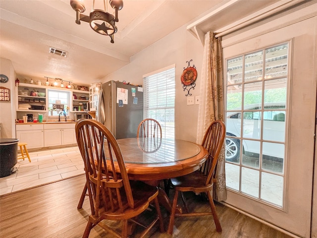 dining area featuring light wood-style floors, visible vents, and plenty of natural light