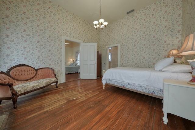 bedroom featuring an inviting chandelier, dark hardwood / wood-style flooring, and vaulted ceiling