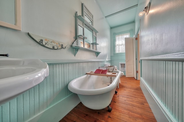 bathroom featuring crown molding, hardwood / wood-style floors, and a bathtub