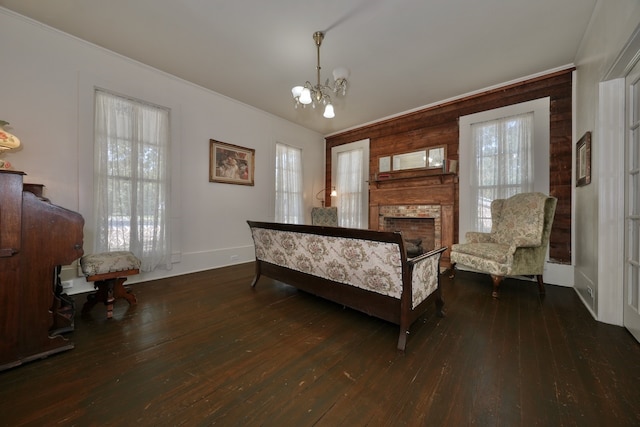 living area featuring a healthy amount of sunlight, a brick fireplace, and dark wood-type flooring