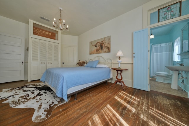 bedroom featuring ensuite bath, dark wood-type flooring, and a closet