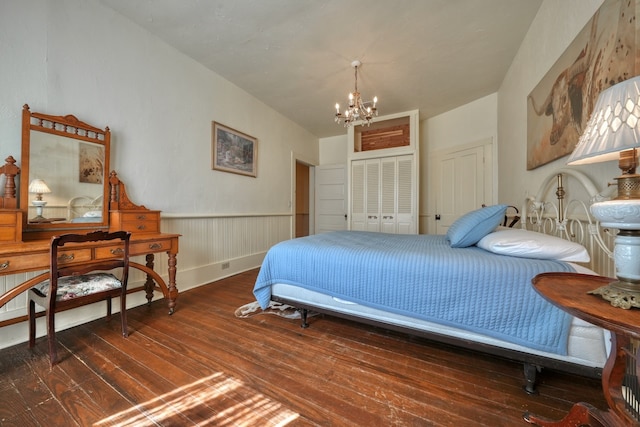 bedroom featuring dark hardwood / wood-style flooring, a chandelier, and a closet