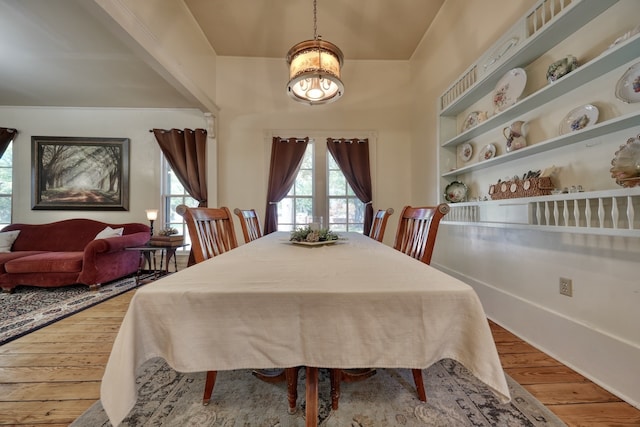 dining area with wood-type flooring and a chandelier