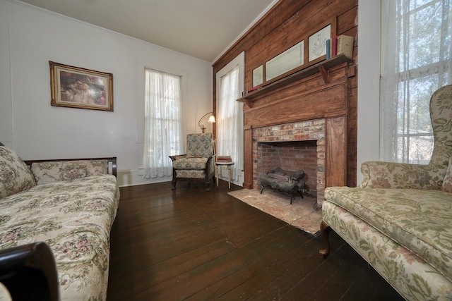 living room with a fireplace, dark hardwood / wood-style flooring, and crown molding