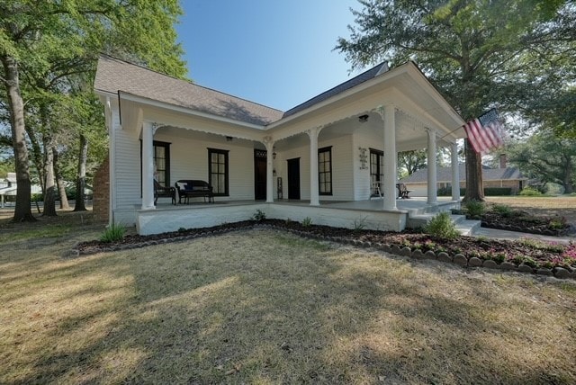 back of house with a porch and a yard