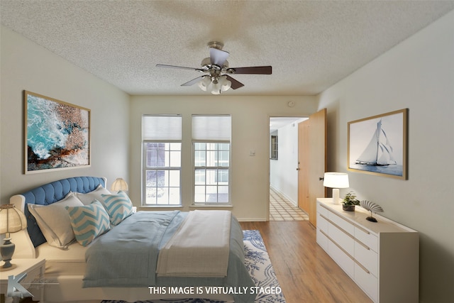 bedroom with light hardwood / wood-style floors, a textured ceiling, and ceiling fan