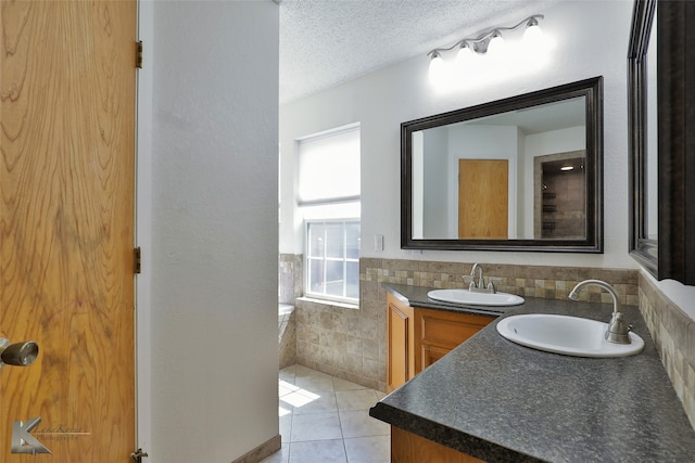 bathroom with vanity, a textured ceiling, and tile patterned flooring