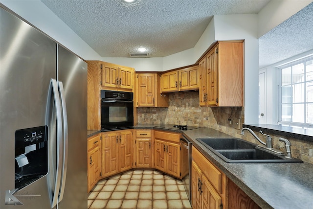 kitchen featuring backsplash, a textured ceiling, black appliances, and sink