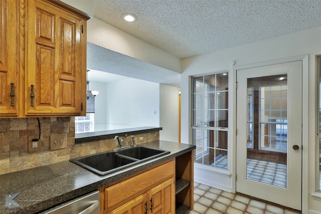 kitchen featuring sink, decorative backsplash, and dishwasher