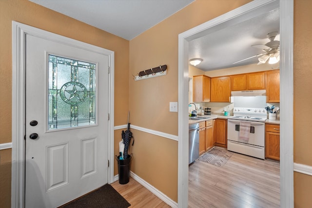 interior space with light wood-type flooring, sink, and ceiling fan