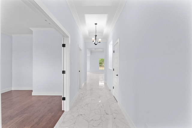 hallway featuring crown molding, wood-type flooring, and a notable chandelier