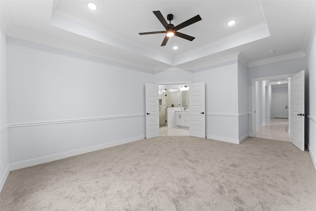 unfurnished bedroom with a tray ceiling, ornamental molding, and ceiling fan