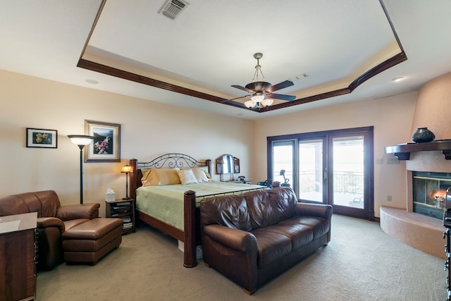 carpeted bedroom with a fireplace, a raised ceiling, access to exterior, and ceiling fan