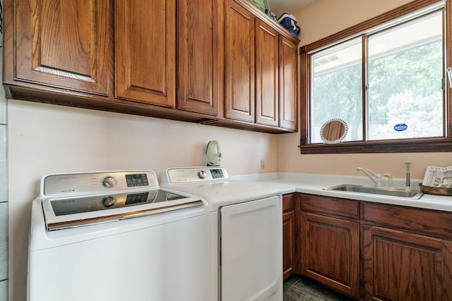 laundry area with cabinets, washing machine and dryer, and sink