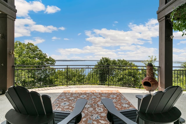 view of patio with a balcony and a water view