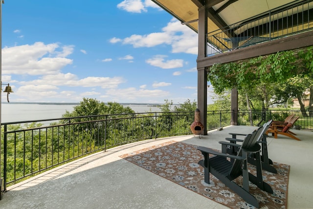 view of patio with a balcony and a water view