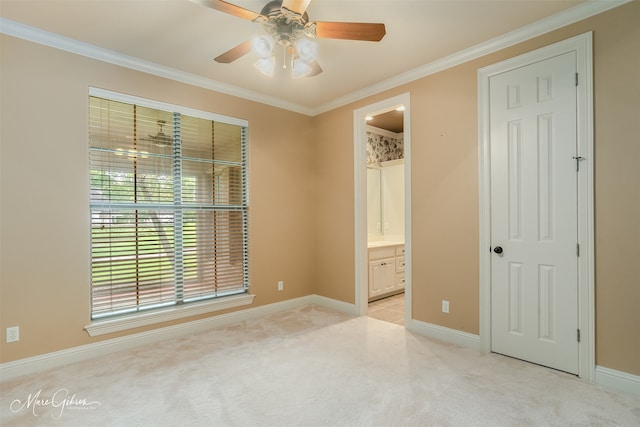 unfurnished bedroom featuring crown molding, connected bathroom, light colored carpet, and ceiling fan