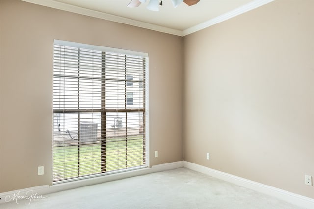 spare room with crown molding, ceiling fan, and light colored carpet