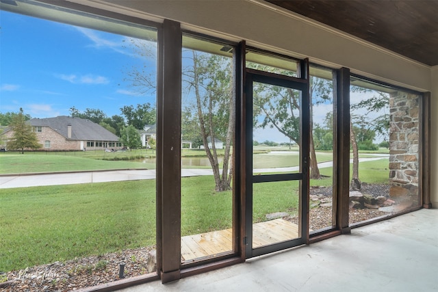 doorway featuring a water view, a wealth of natural light, and ornamental molding