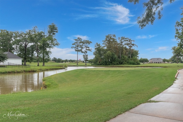 view of property's community featuring a water view and a yard