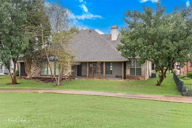 view of front of house with a front lawn and central AC