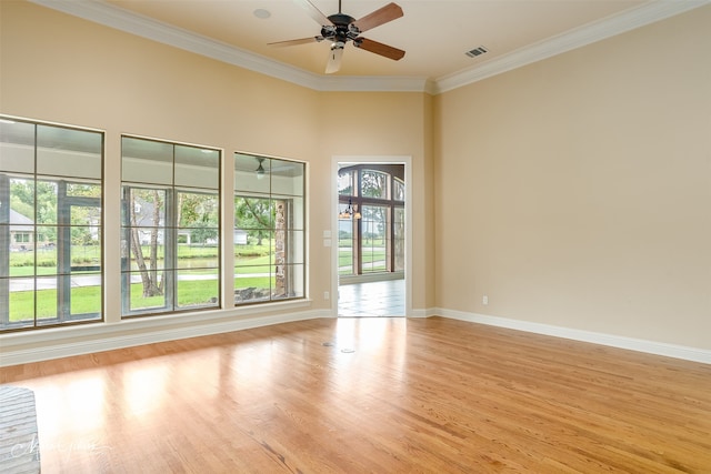 empty room with ornamental molding, a wealth of natural light, light hardwood / wood-style flooring, and ceiling fan