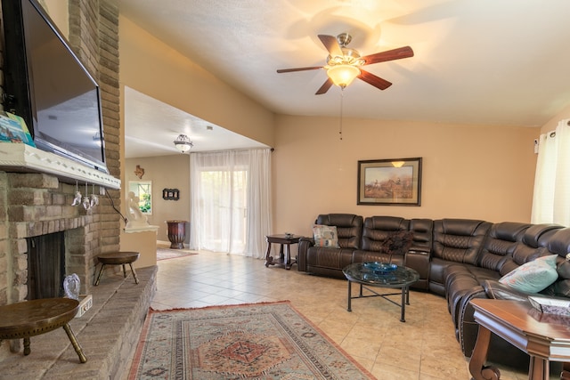 living room with ceiling fan, vaulted ceiling, light tile patterned flooring, and a brick fireplace