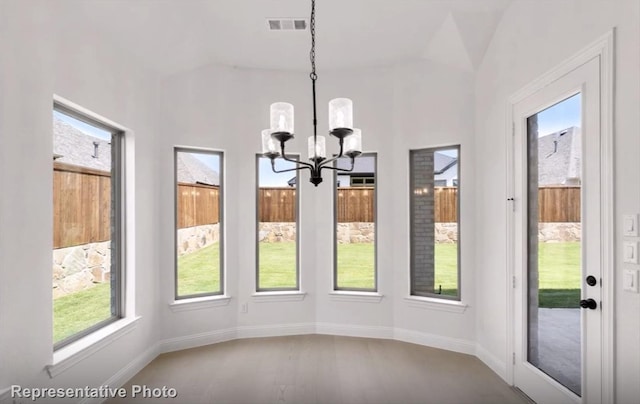 unfurnished dining area featuring a chandelier, visible vents, and baseboards