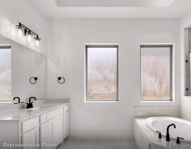 full bath with vanity, a raised ceiling, and a wealth of natural light