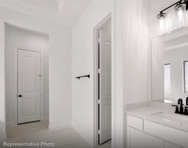 bathroom with vanity, baseboards, and wood finished floors