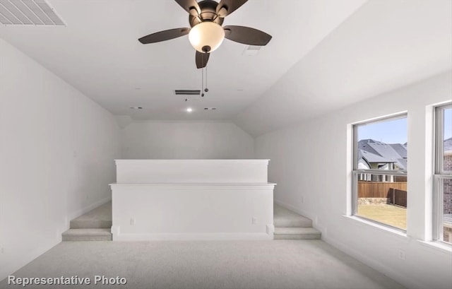 additional living space featuring lofted ceiling, plenty of natural light, and visible vents