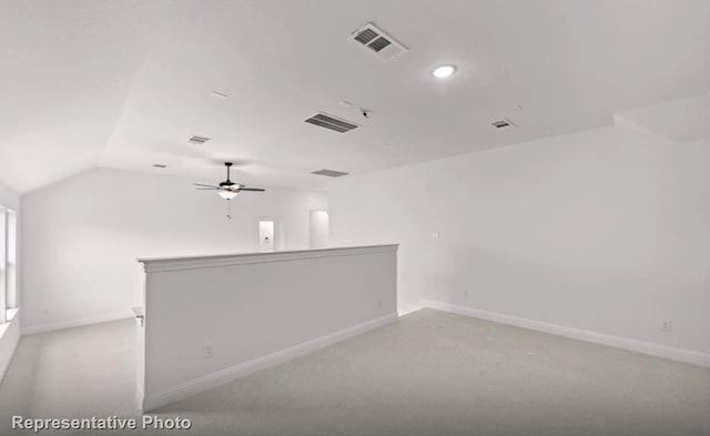 spare room with vaulted ceiling, visible vents, and baseboards