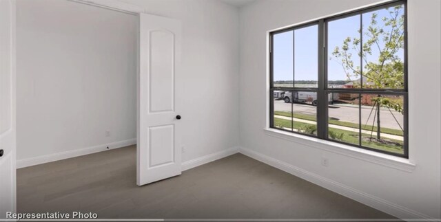 empty room featuring wood finished floors and baseboards