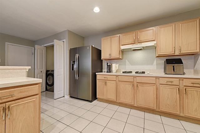 kitchen featuring washer / dryer, light brown cabinets, and stainless steel refrigerator with ice dispenser