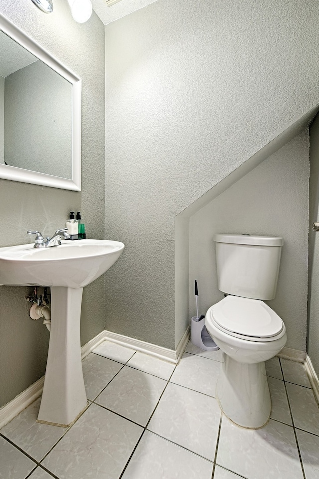 bathroom with toilet and tile patterned floors