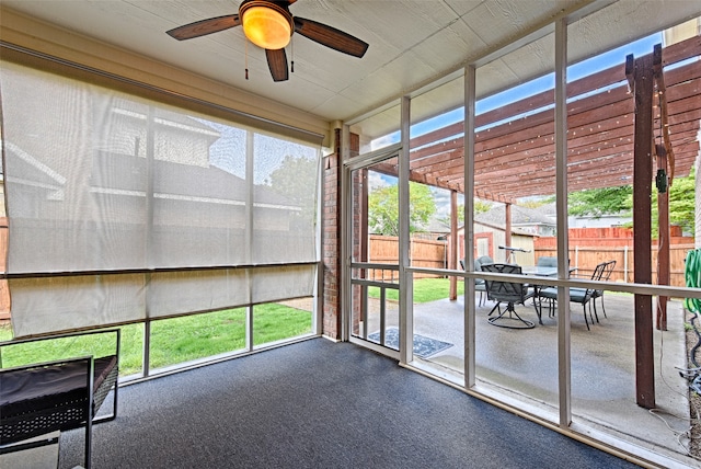 unfurnished sunroom featuring ceiling fan