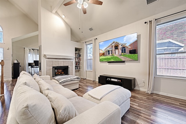 living room featuring high vaulted ceiling, hardwood / wood-style flooring, ceiling fan, and a tile fireplace