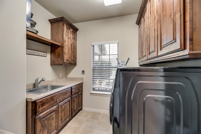 clothes washing area with a wealth of natural light, cabinets, washer / dryer, and sink