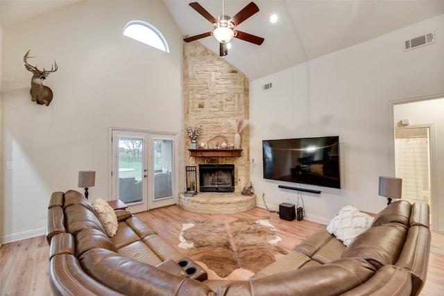 living room with light hardwood / wood-style flooring, ceiling fan, and high vaulted ceiling