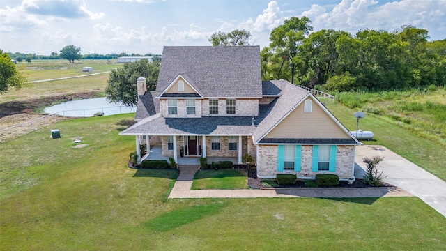 10200 Zipper Rd, Pilot Point, TX 76258 - view of front facade with a porch, a front yard, a shingled roof, a chimney, and brick siding