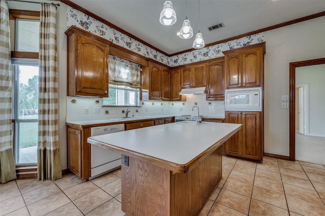 kitchen with crown molding, decorative light fixtures, white appliances, a notable chandelier, and a kitchen island with sink