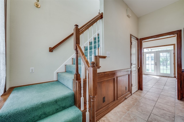 stairway featuring tile patterned floors and french doors