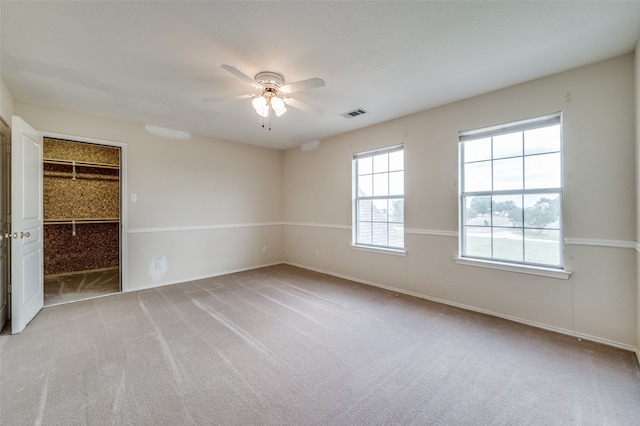 carpeted spare room with ceiling fan