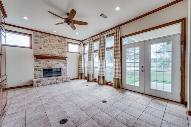 unfurnished living room with a fireplace, crown molding, french doors, light tile patterned flooring, and ceiling fan