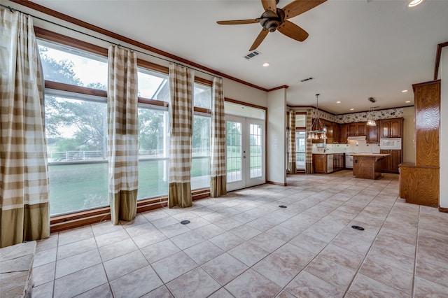 unfurnished living room with ceiling fan, crown molding, and french doors